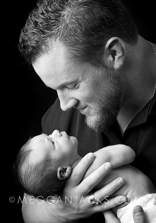 black white photo of dad holding newborn baby boy